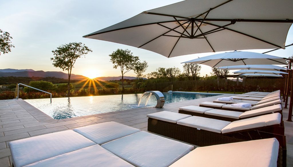 Picture of a nice pool with seats during a sunset